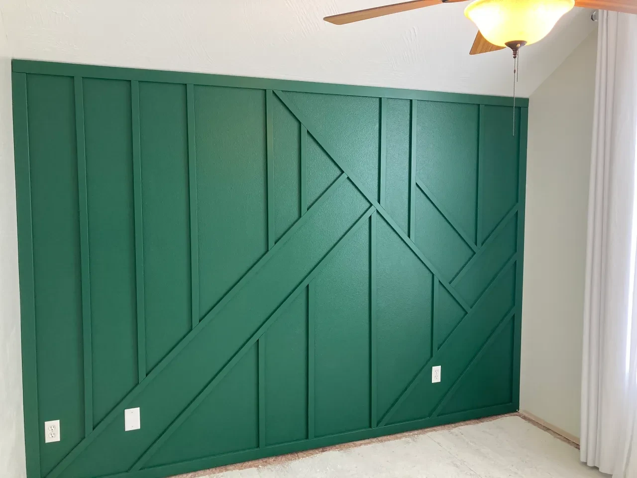 Green geometric wall paneling with herringbone pattern