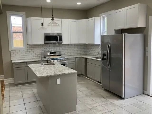 Renovated kitchen with gray cabinets and subway tile
