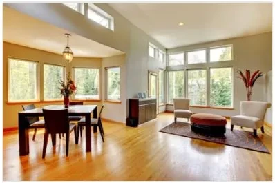 Open living and dining room with hardwood floors and large windows